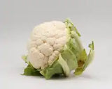 Fresh ZabhiaNow cauliflower head with green leaves, showcasing its white, compact, and healthy appearance.